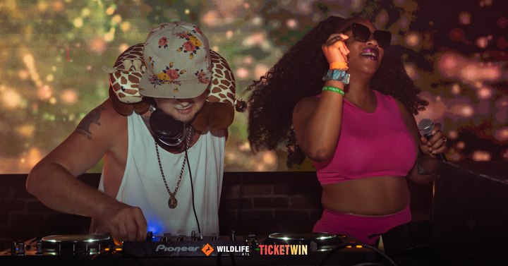 A DJ in a floral bucket hat working the decks while a dancer in pink moves beside the booth